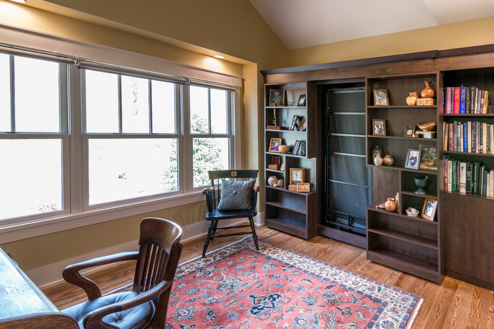 Idéer för att renovera ett mellanstort amerikanskt arbetsrum, med ett bibliotek, beige väggar, mellanmörkt trägolv, ett fristående skrivbord och brunt golv