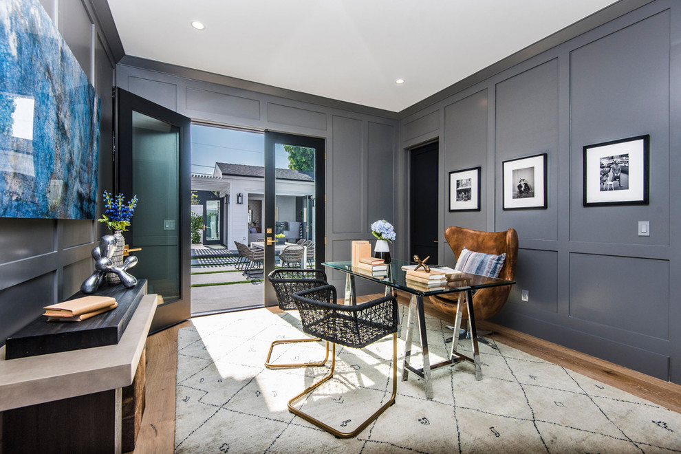 Imagen de despacho costero con paredes grises, suelo de madera clara, escritorio independiente y suelo beige