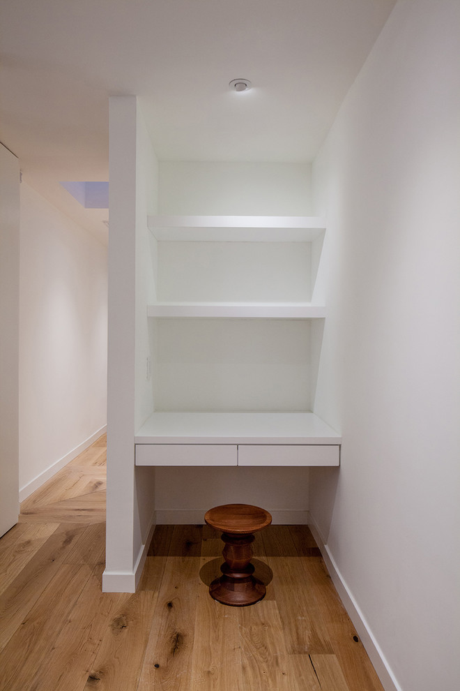 Inspiration for a small contemporary built-in desk light wood floor and brown floor study room remodel in Los Angeles with white walls and no fireplace
