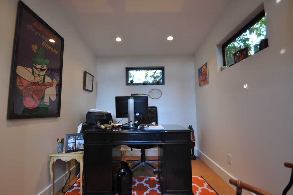 Modelo de despacho minimalista pequeño con paredes blancas, suelo laminado y escritorio independiente
