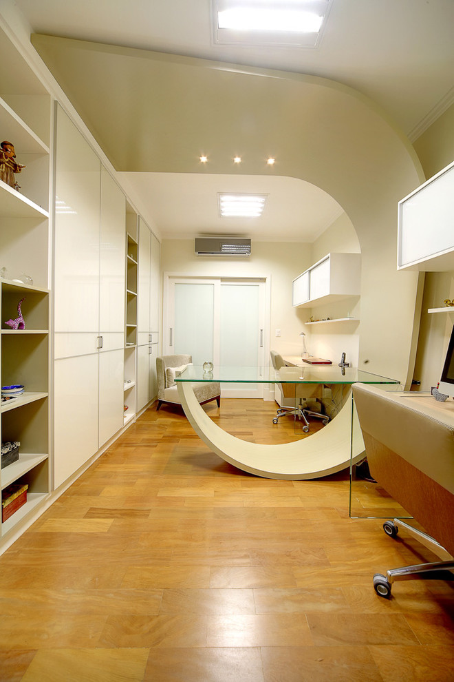 Inspiration for a contemporary medium tone wood floor home office remodel with beige walls