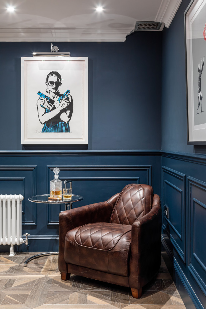 ロンドンにある広いトランジショナルスタイルのおしゃれな書斎 (青い壁、無垢フローリング、茶色い床、パネル壁) の写真
