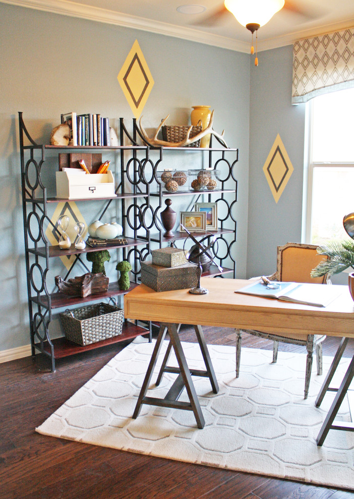 Ejemplo de despacho bohemio con paredes azules, suelo de madera oscura y escritorio independiente
