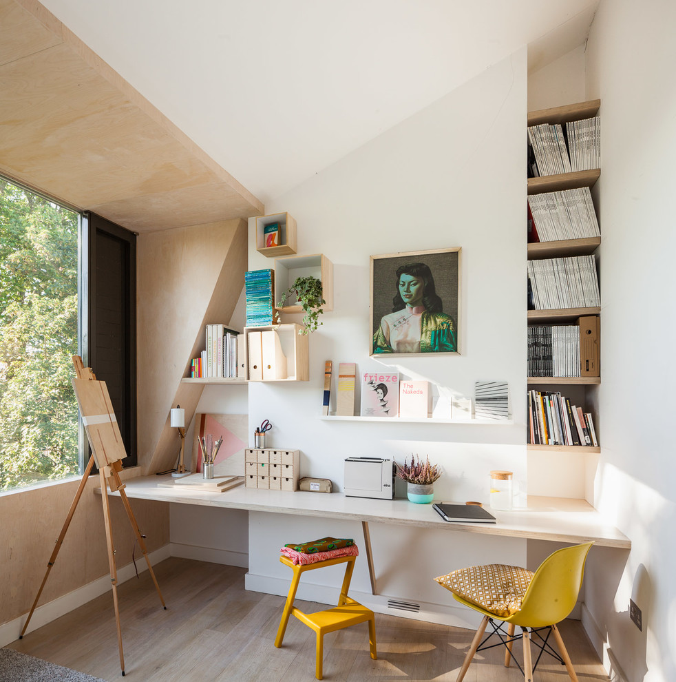 Mittelgroßes Modernes Nähzimmer mit weißer Wandfarbe, hellem Holzboden, Einbau-Schreibtisch und braunem Boden in London