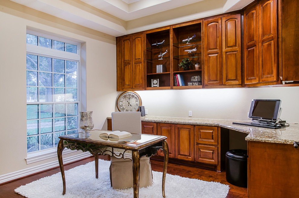 Mittelgroßes Klassisches Lesezimmer ohne Kamin mit beiger Wandfarbe, dunklem Holzboden und freistehendem Schreibtisch in Houston