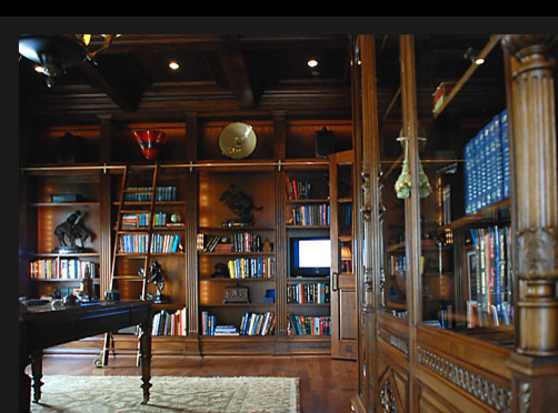 Foto på ett stort hemmabibliotek, med ett fristående skrivbord