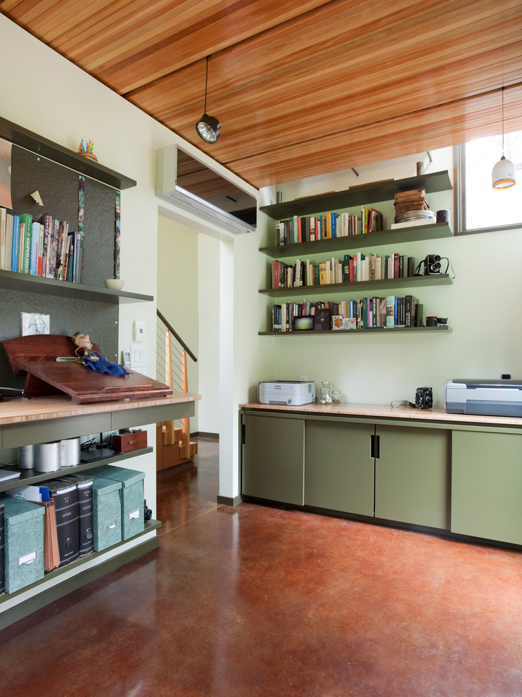 Cette image montre un bureau minimaliste avec un mur vert et un sol rouge.