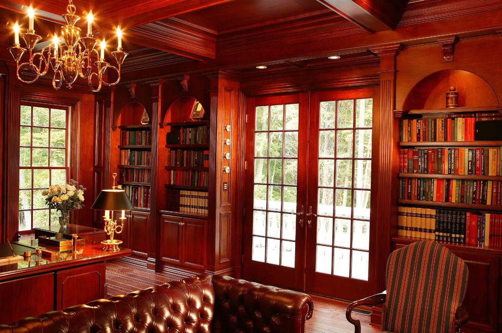 Источник вдохновения для домашнего уюта: большой кабинет в викторианском стиле с коричневыми стенами, темным паркетным полом, встроенным рабочим столом и коричневым полом без камина