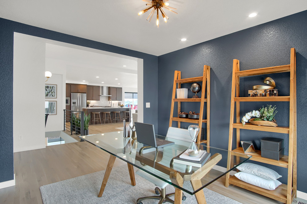 Imagen de despacho retro de tamaño medio con paredes azules, suelo de madera clara, escritorio independiente y suelo beige