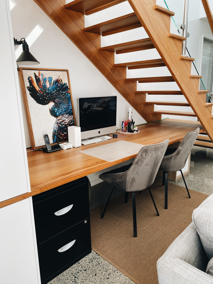 Immagine di un piccolo ufficio design con pareti bianche, scrivania incassata e pannellatura