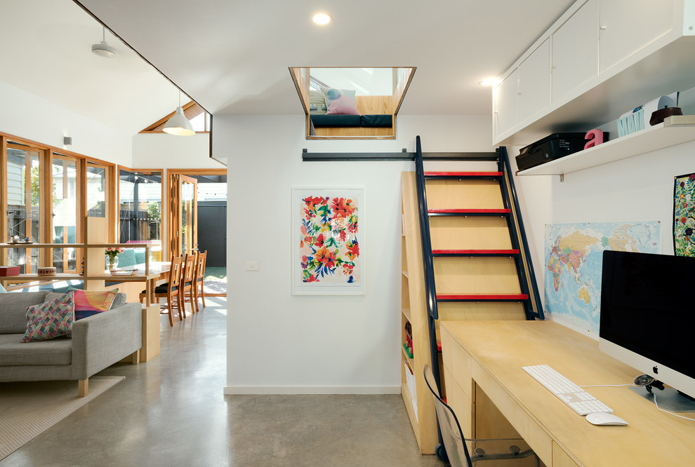 Inspiration for a mid-sized contemporary built-in desk concrete floor study room remodel in Melbourne with white walls