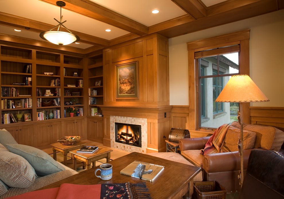 Exempel på ett stort klassiskt arbetsrum, med ett bibliotek, ljust trägolv, en standard öppen spis, en spiselkrans i trä och ett fristående skrivbord