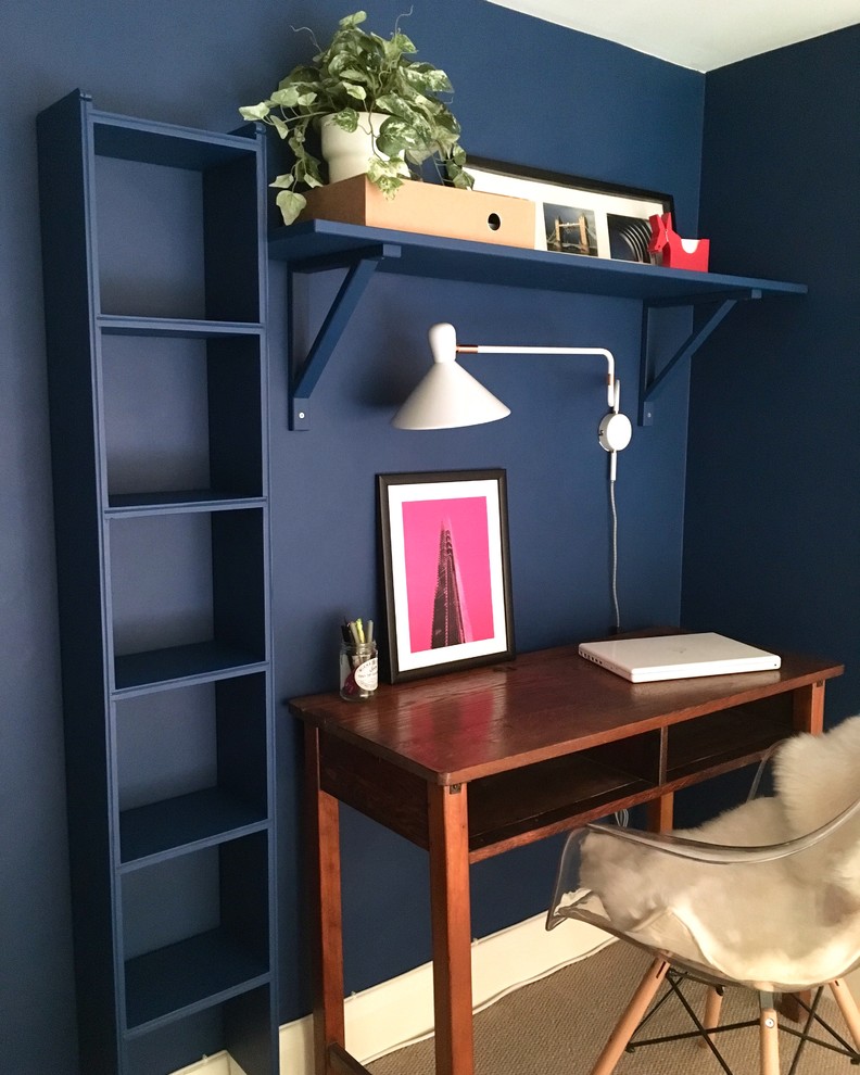 Kleines Modernes Arbeitszimmer mit Arbeitsplatz, blauer Wandfarbe, Teppichboden und freistehendem Schreibtisch in London