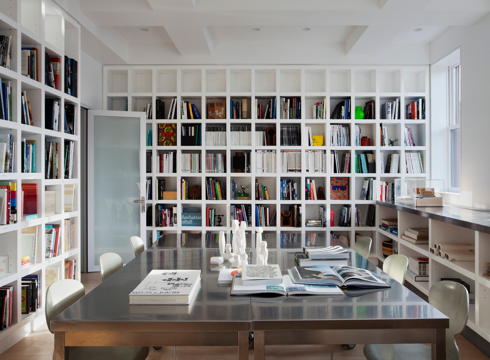 Immagine di uno studio minimalista con pareti bianche, scrivania autoportante e libreria