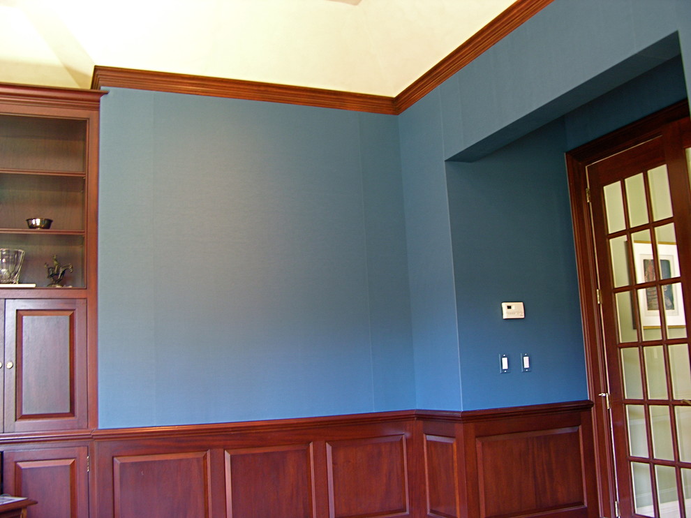 ニューヨークにあるトラディショナルスタイルのおしゃれなホームオフィス・書斎 (青い壁、淡色無垢フローリング、コーナー設置型暖炉、石材の暖炉まわり) の写真