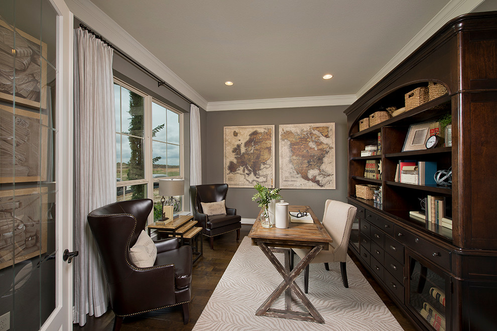 This is an example of a classic study in Houston with grey walls, medium hardwood flooring, no fireplace and a freestanding desk.