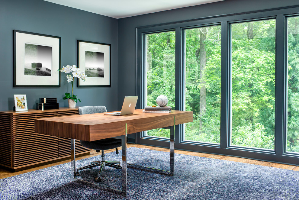 Foto di uno studio contemporaneo con pareti blu, pavimento in legno massello medio, scrivania autoportante e pavimento marrone