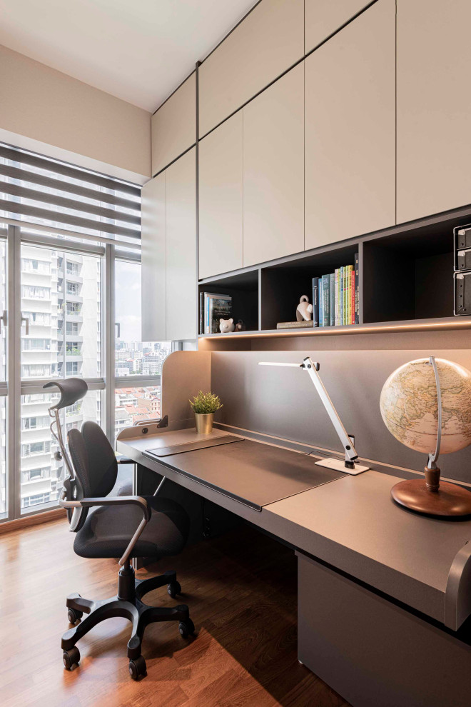 Großes Modernes Arbeitszimmer mit Arbeitsplatz, weißer Wandfarbe, braunem Holzboden, Einbau-Schreibtisch und braunem Boden in Singapur