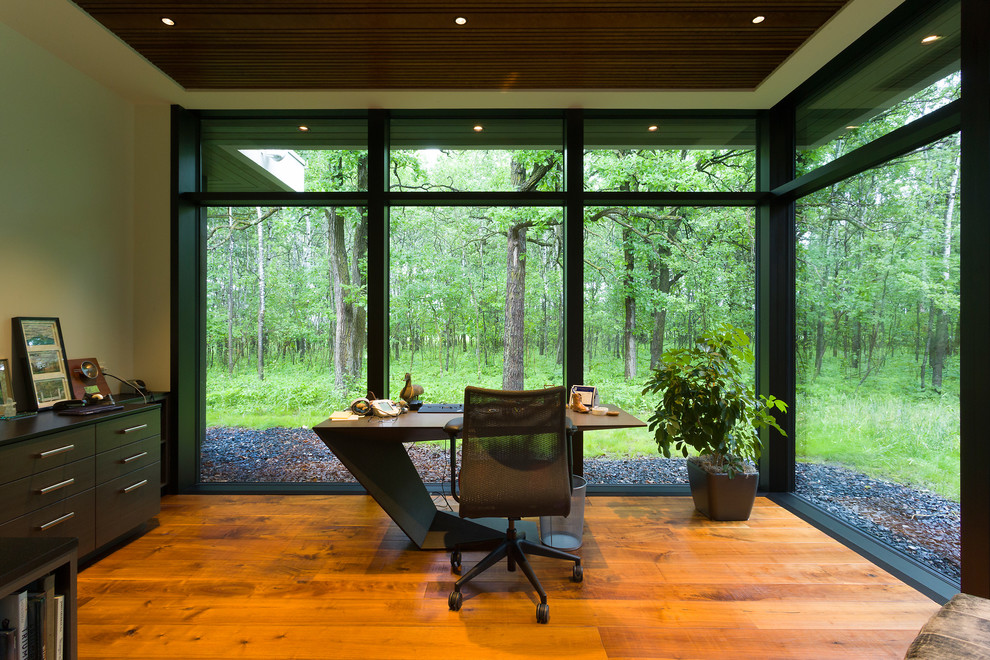 Foto de despacho contemporáneo extra grande con paredes blancas, suelo de madera en tonos medios, escritorio independiente y suelo marrón