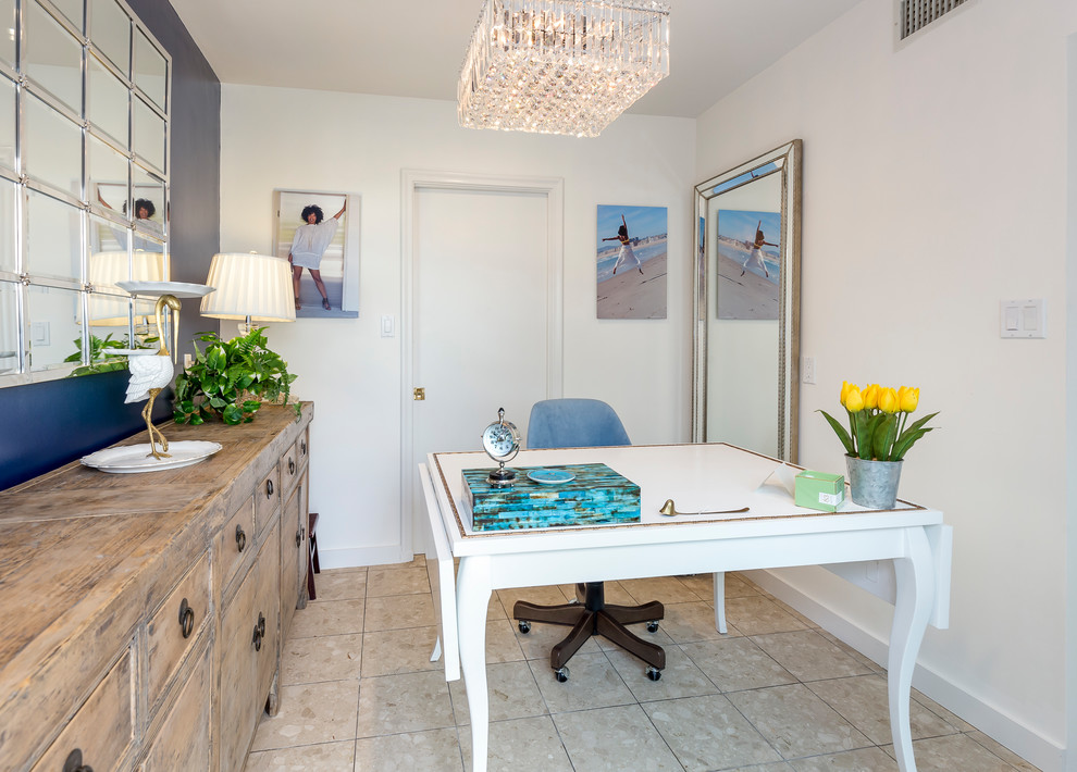Cette photo montre un petit bureau atelier chic avec un mur bleu, aucune cheminée, un bureau indépendant, un sol en travertin et un sol beige.