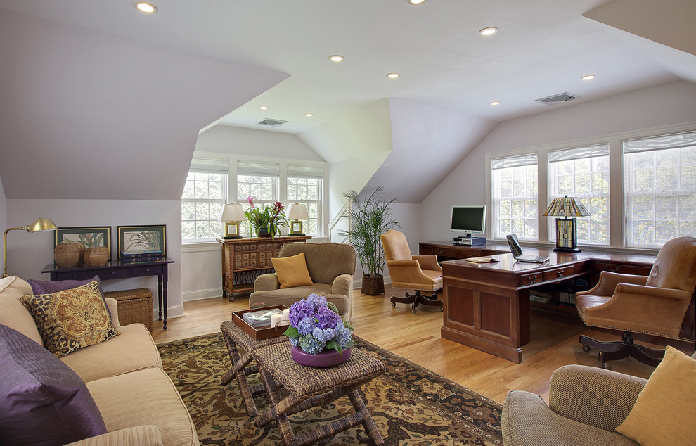 Ejemplo de despacho tradicional grande con escritorio empotrado, paredes blancas y suelo de madera en tonos medios