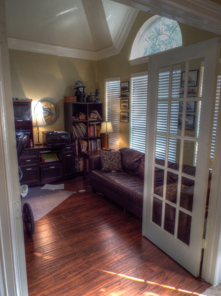 Imagen de despacho clásico renovado de tamaño medio con paredes beige, suelo laminado, escritorio independiente y suelo marrón