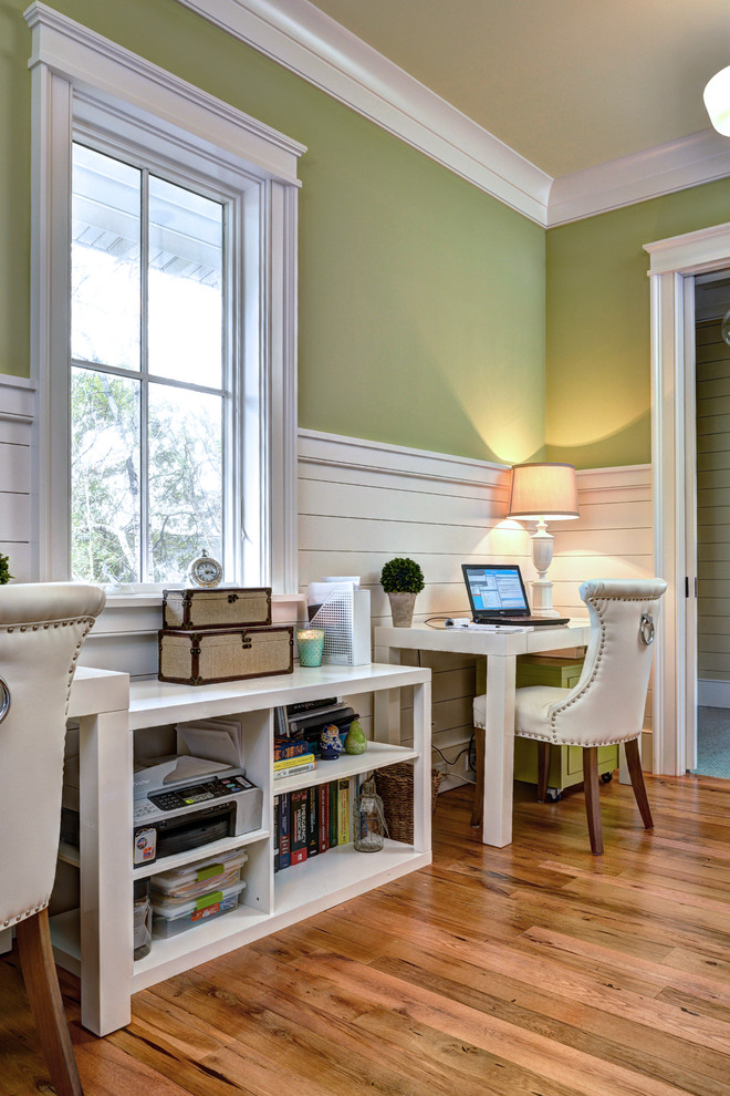 Maritimes Arbeitszimmer mit grüner Wandfarbe, braunem Holzboden und freistehendem Schreibtisch in Charleston