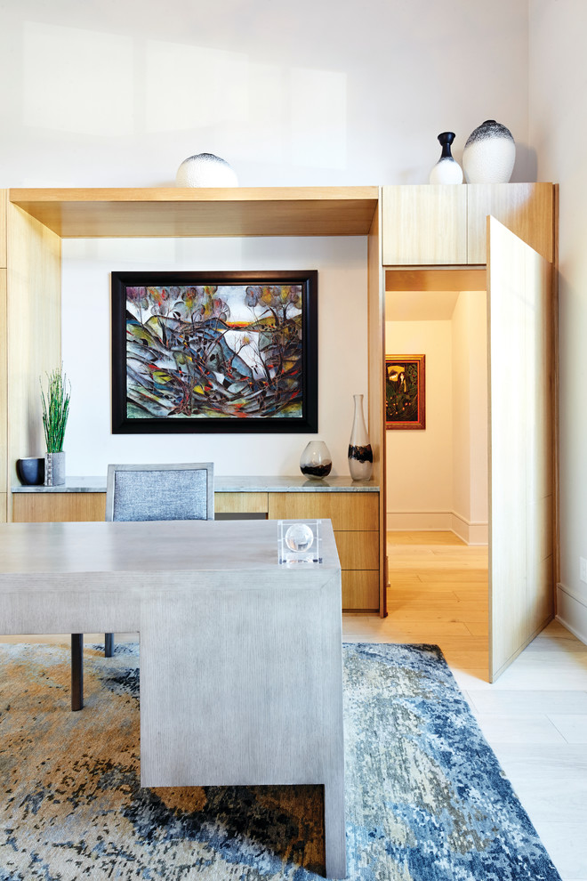 Cette image montre un très grand bureau design avec un mur blanc, parquet clair, un bureau indépendant et un sol marron.