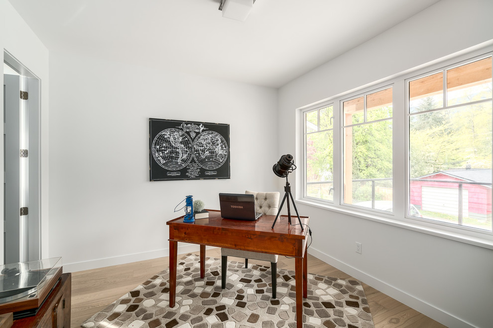 Ejemplo de despacho clásico renovado de tamaño medio con paredes blancas, suelo de madera clara y escritorio independiente