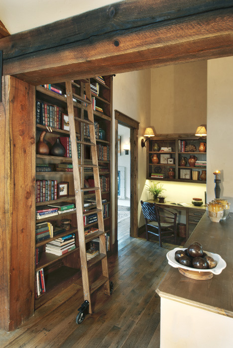 Esempio di un grande studio rustico con libreria, pareti beige, pavimento in legno massello medio, nessun camino, scrivania incassata e pavimento marrone