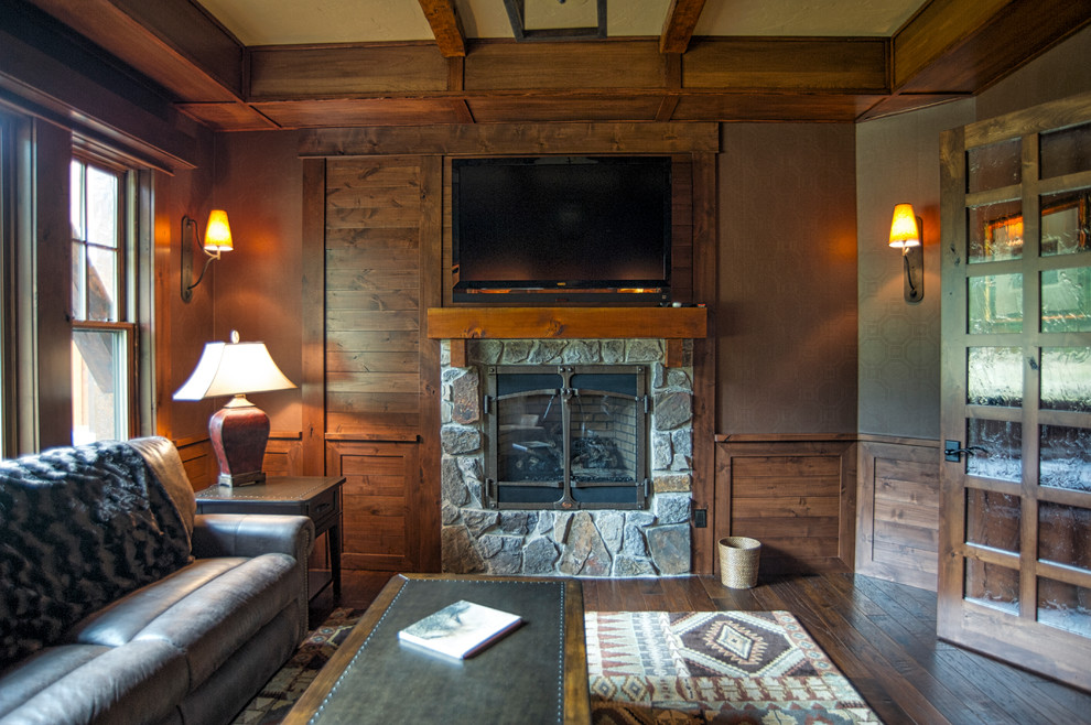 シアトルにあるラスティックスタイルのおしゃれなホームオフィス・書斎 (濃色無垢フローリング、横長型暖炉、石材の暖炉まわり、造り付け机) の写真