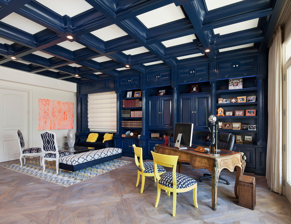 Идея дизайна: рабочее место в классическом стиле с синими стенами, светлым паркетным полом, отдельно стоящим рабочим столом и коричневым полом