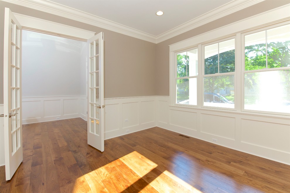 Imagen de despacho clásico grande con paredes grises, suelo de madera clara y suelo marrón