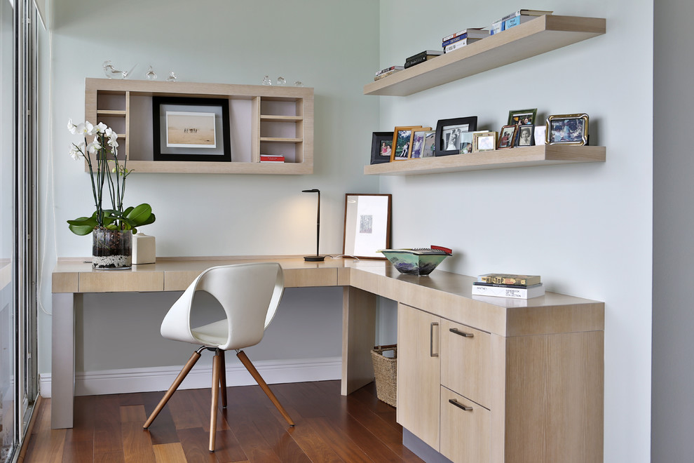 Idée de décoration pour un bureau design de taille moyenne avec un mur bleu, un sol en bois brun, aucune cheminée, un bureau intégré et un sol beige.