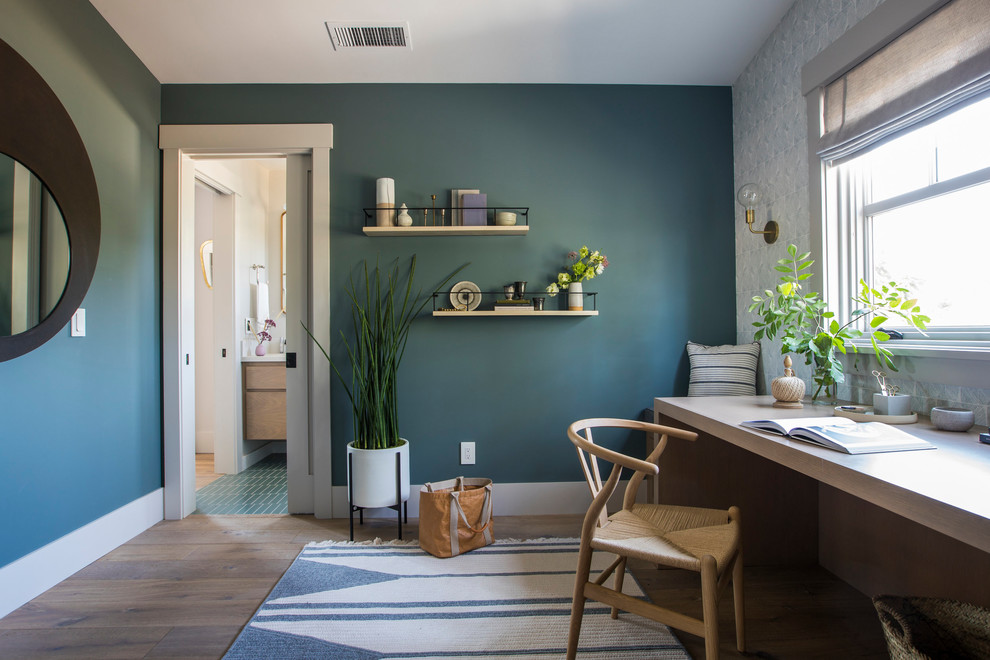 Foto di uno studio design con pareti blu, pavimento in legno massello medio, scrivania incassata e pavimento marrone
