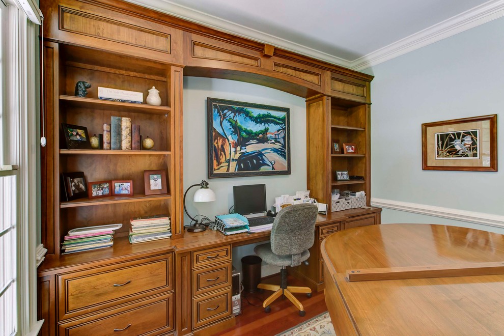 Immagine di un piccolo ufficio chic con pareti blu, pavimento in legno massello medio, nessun camino e scrivania incassata