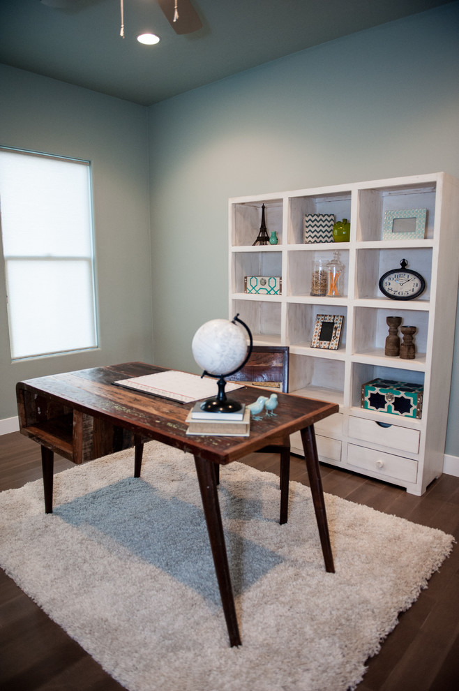 Ejemplo de despacho actual de tamaño medio con paredes grises, suelo de madera oscura, escritorio independiente y suelo marrón