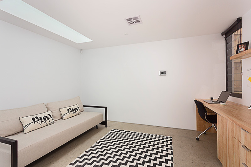 Réalisation d'un grand bureau design avec un mur blanc, sol en béton ciré, un bureau intégré et un sol gris.