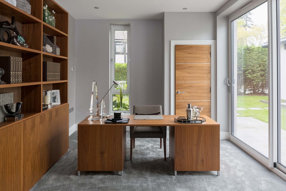 Ejemplo de despacho minimalista grande con paredes grises, moqueta, escritorio independiente y suelo gris