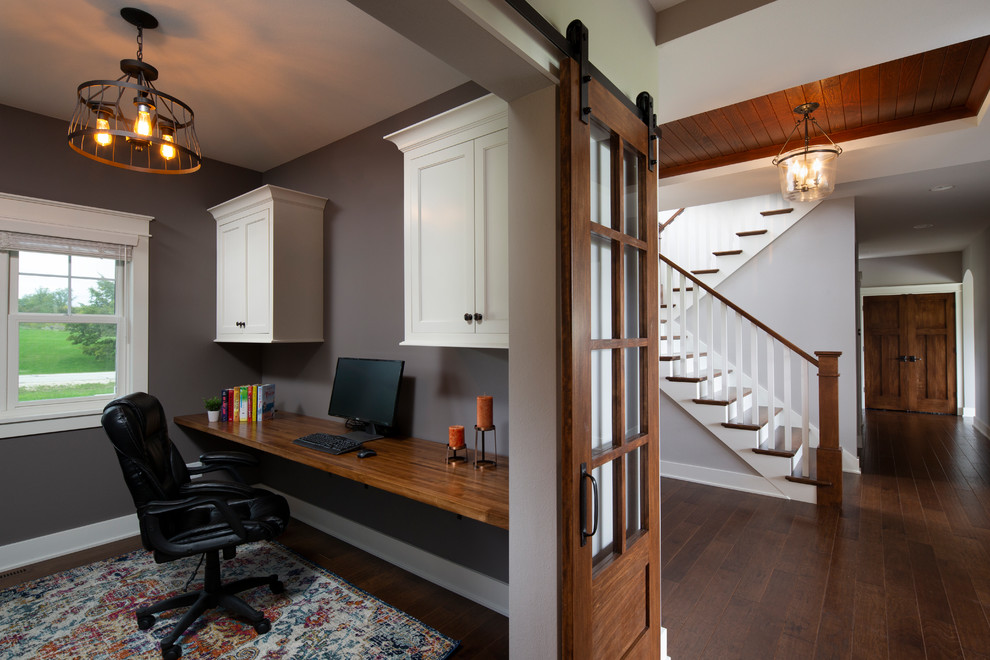 Idée de décoration pour un petit bureau craftsman avec un mur gris, parquet foncé, un bureau intégré et un sol marron.