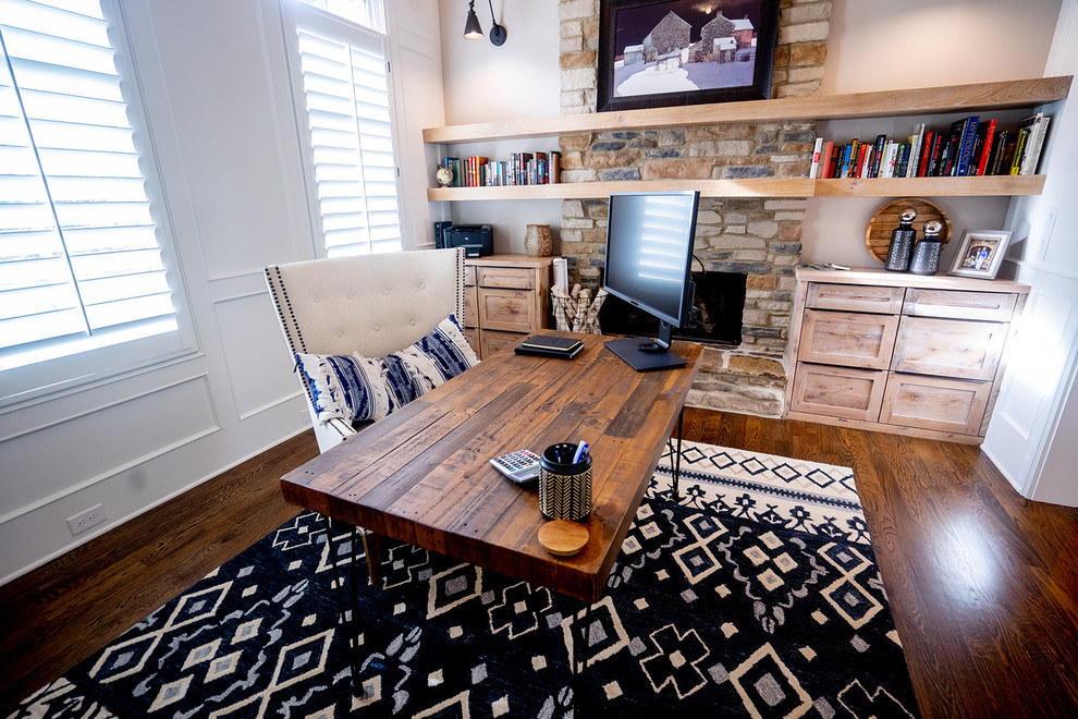 Aménagement d'un bureau classique de taille moyenne avec un mur gris, parquet clair, une cheminée standard, un manteau de cheminée en pierre, un bureau indépendant et un sol marron.