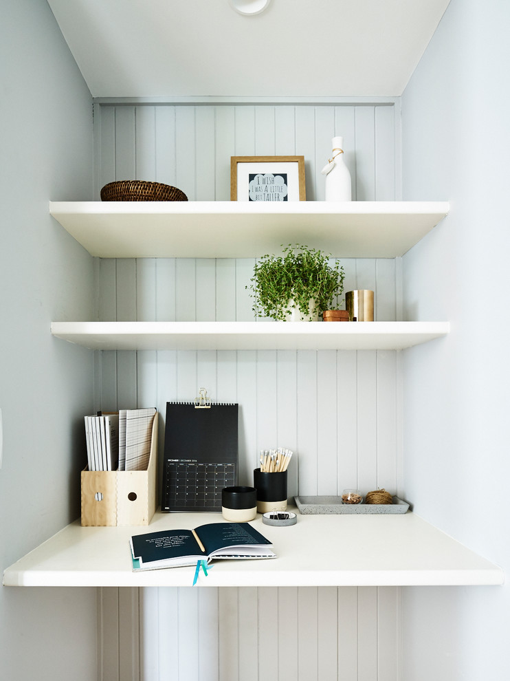 Imagen de despacho clásico renovado pequeño con paredes azules y escritorio empotrado