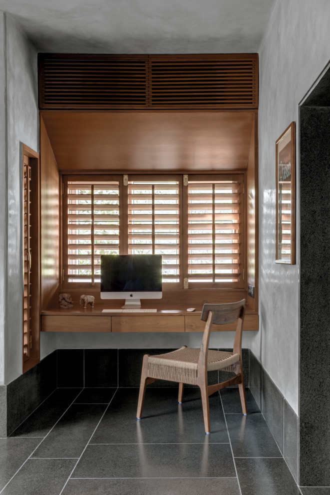 Cette photo montre un bureau tendance avec un mur gris, un bureau intégré et un sol gris.