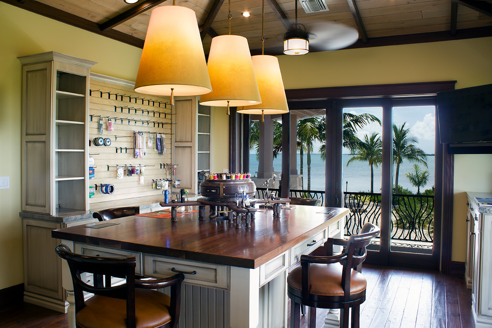 Craft room - tropical freestanding desk dark wood floor and brown floor craft room idea in Miami with yellow walls and no fireplace