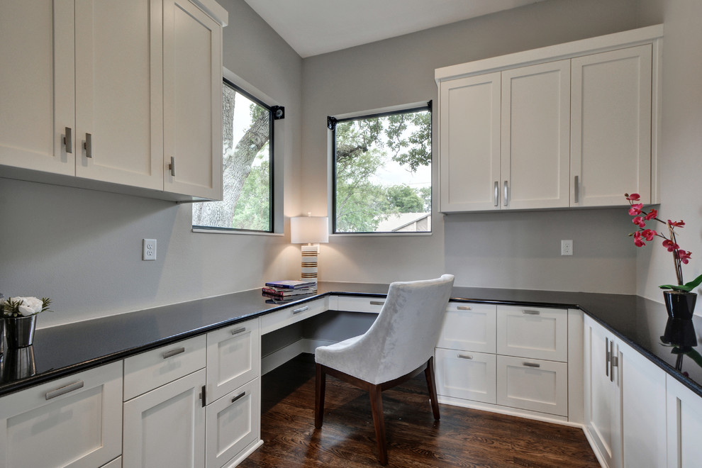 This is an example of a medium sized modern study in Austin with grey walls, medium hardwood flooring and a built-in desk.