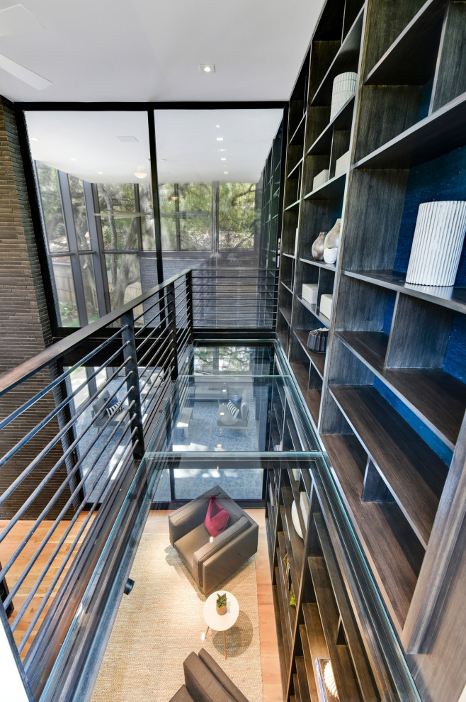 Diseño de despacho moderno grande con biblioteca, paredes azules y escritorio empotrado
