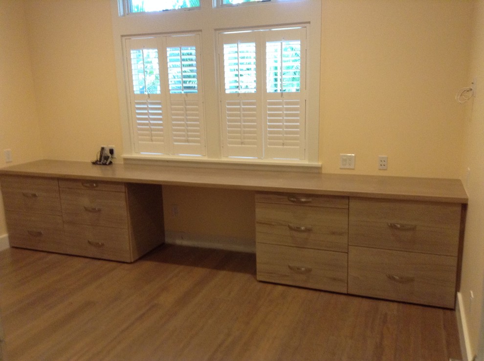 Inspiration for a large modern built-in desk medium tone wood floor study room remodel in Other