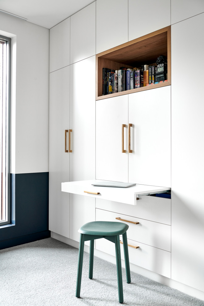 На фото: кабинет среднего размера в скандинавском стиле с белыми стенами, ковровым покрытием и серым полом с