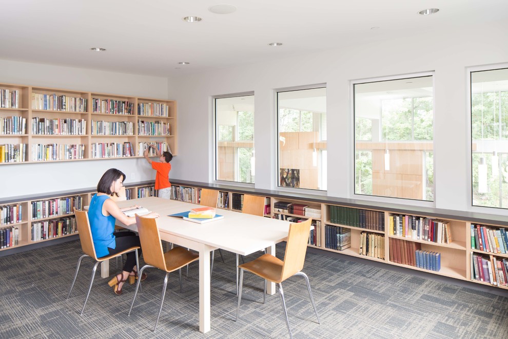 Diseño de despacho actual grande sin chimenea con biblioteca, paredes blancas, moqueta, escritorio independiente y suelo blanco
