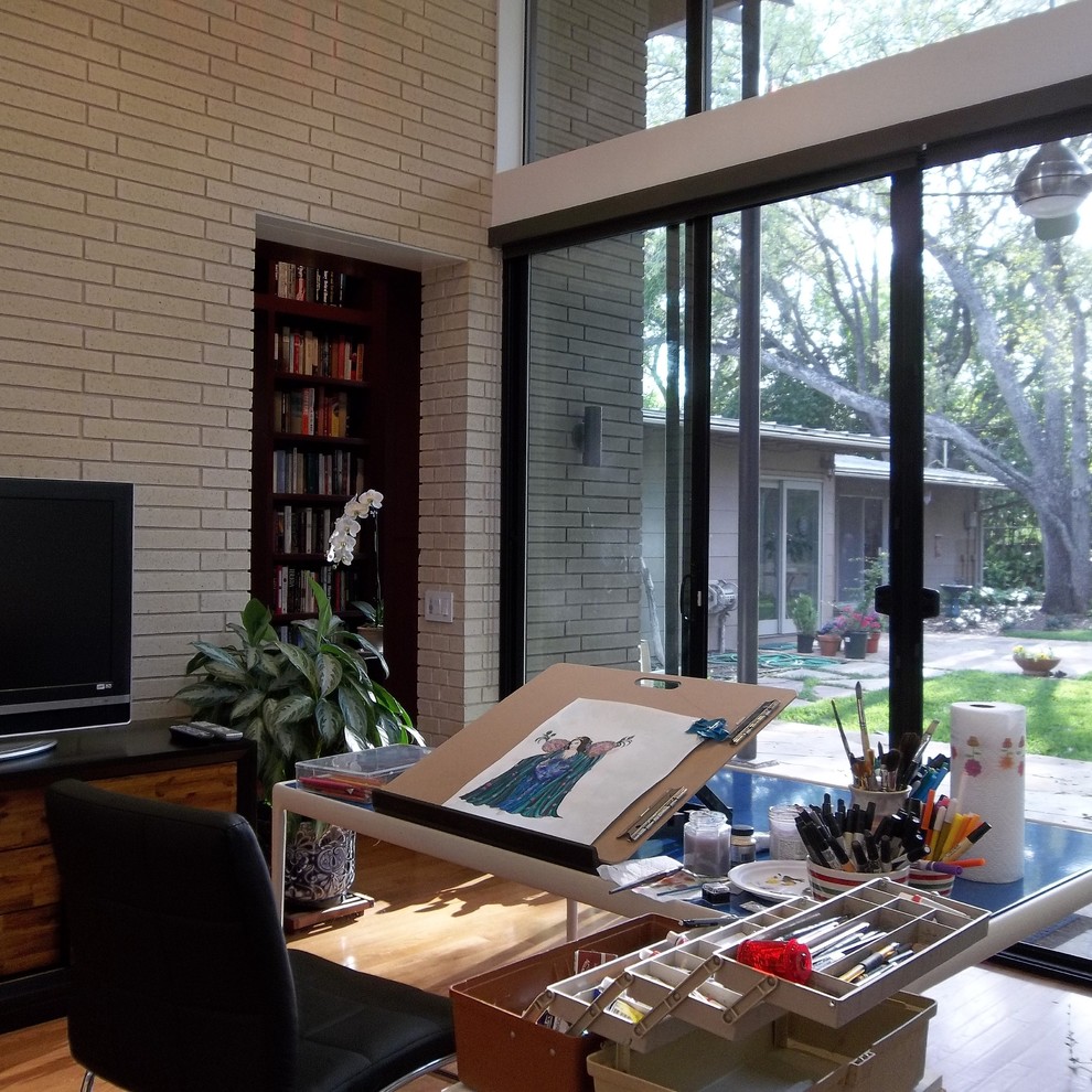 Photo of a contemporary home studio in Austin with medium hardwood flooring and a freestanding desk.